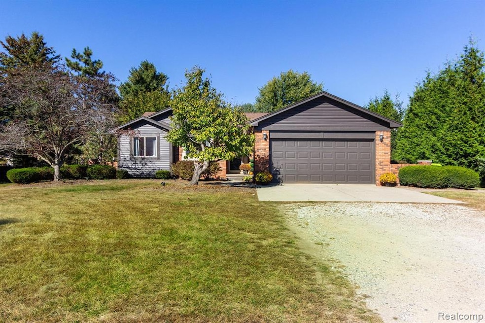 Single story home with driveway, a front yard, brick siding, and a garage
