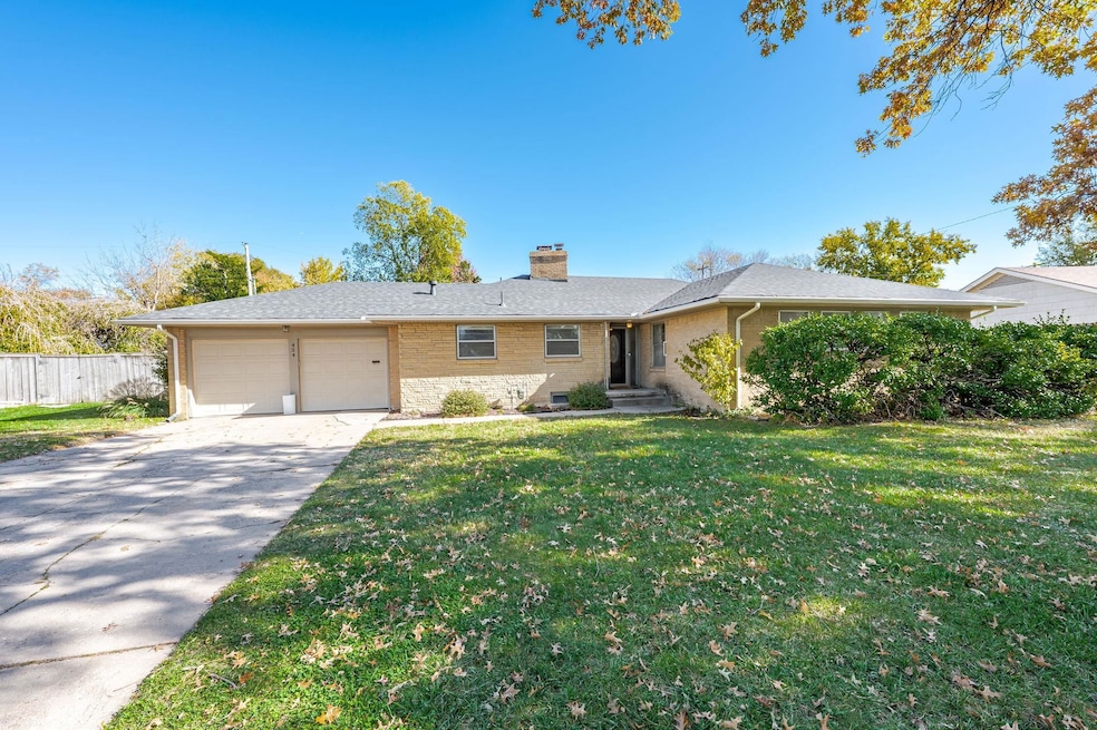 Single story home with a chimney, driveway, brick siding, a garage, and roof with shingles