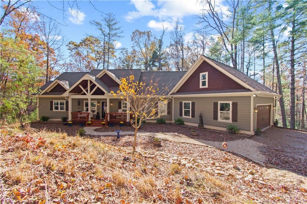 Craftsman-style home featuring covered porch, an attached garage, and roof with shingles