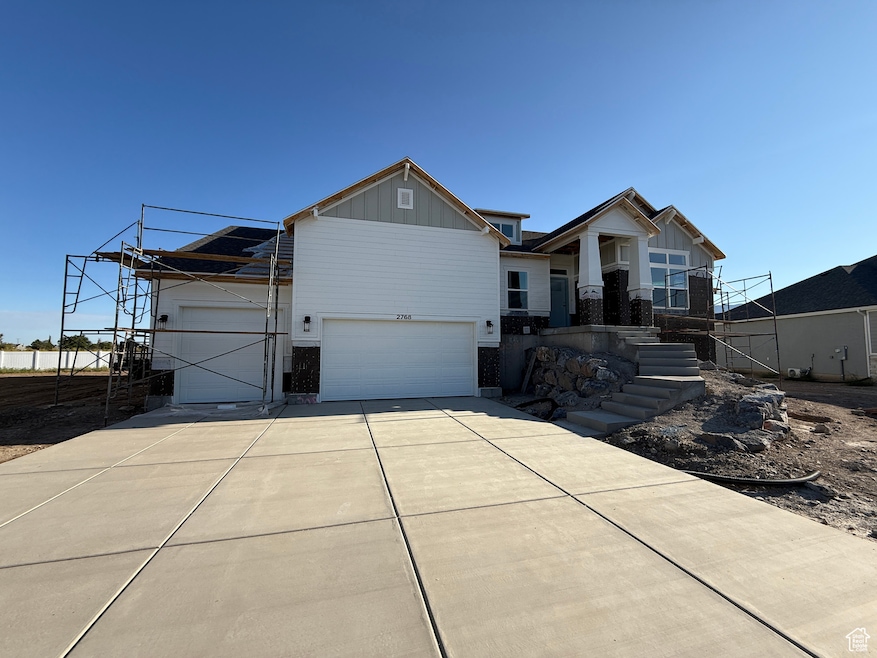 Craftsman-style home featuring board and batten siding, driveway, and a garage