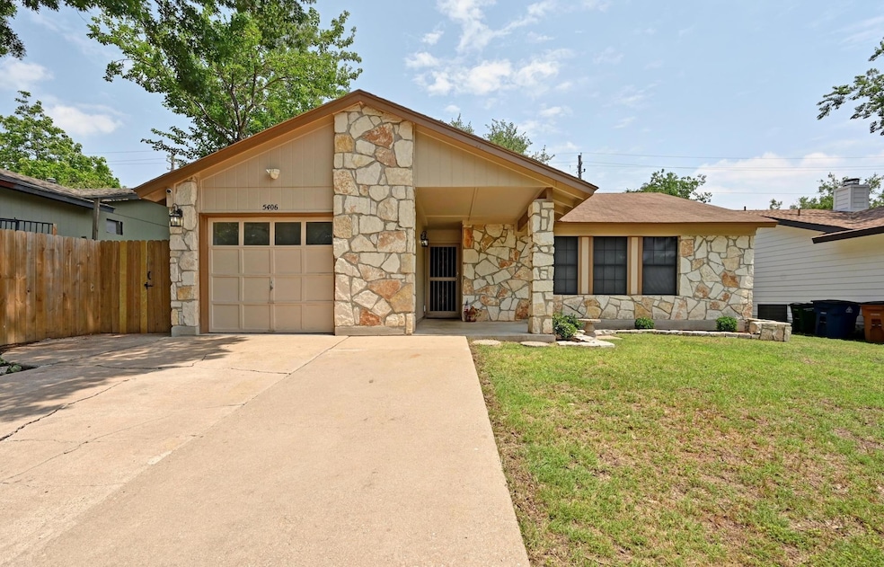 View of front facade featuring stone siding, a ga