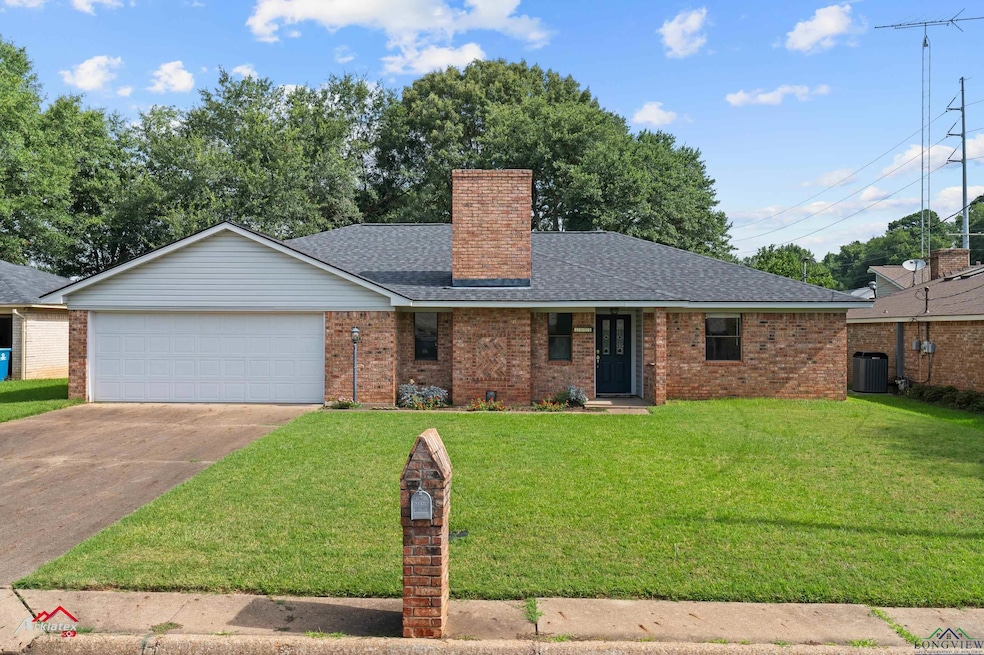 Ranch-style home featuring a chimney, a garage, concrete driveway, brick siding, and a shingled roof