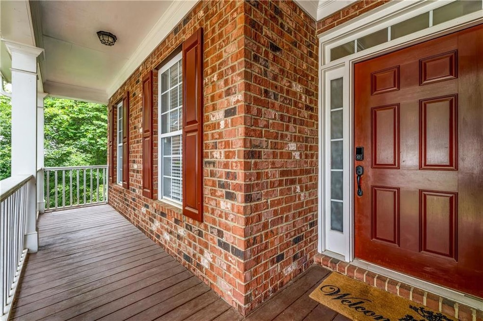 View of exterior entry with covered porch and brick siding