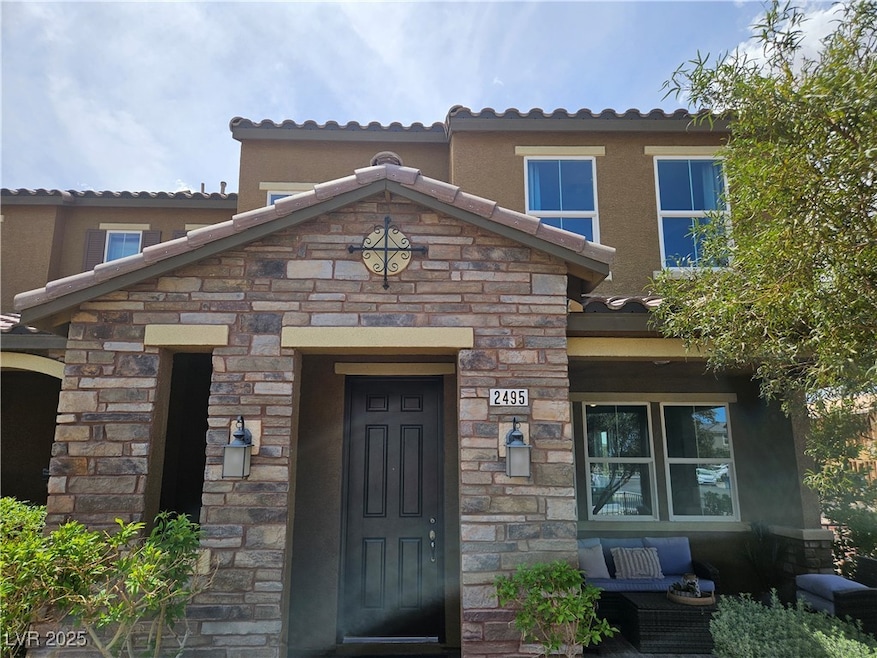 Entrance to property featuring stone siding, stucc