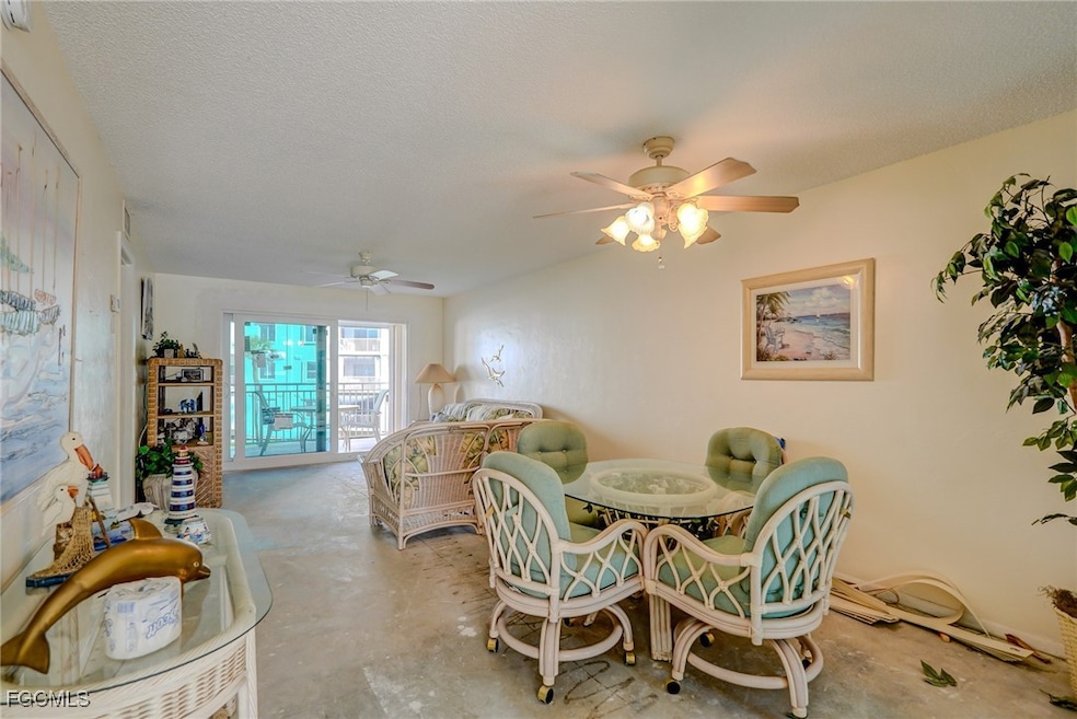 Dining space featuring concrete flooring, a textured ceiling, and ceiling fan