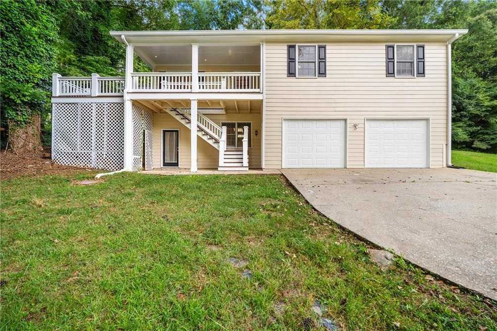 View of front of home featuring concrete driveway, stairway, a garage, and a front lawn
