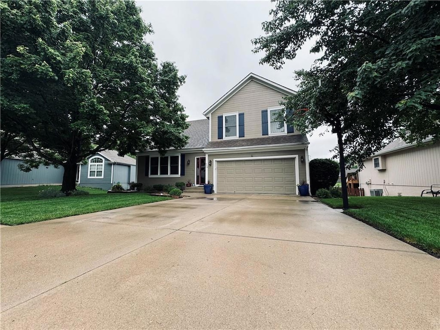 Front facade featuring a front yard and a garage