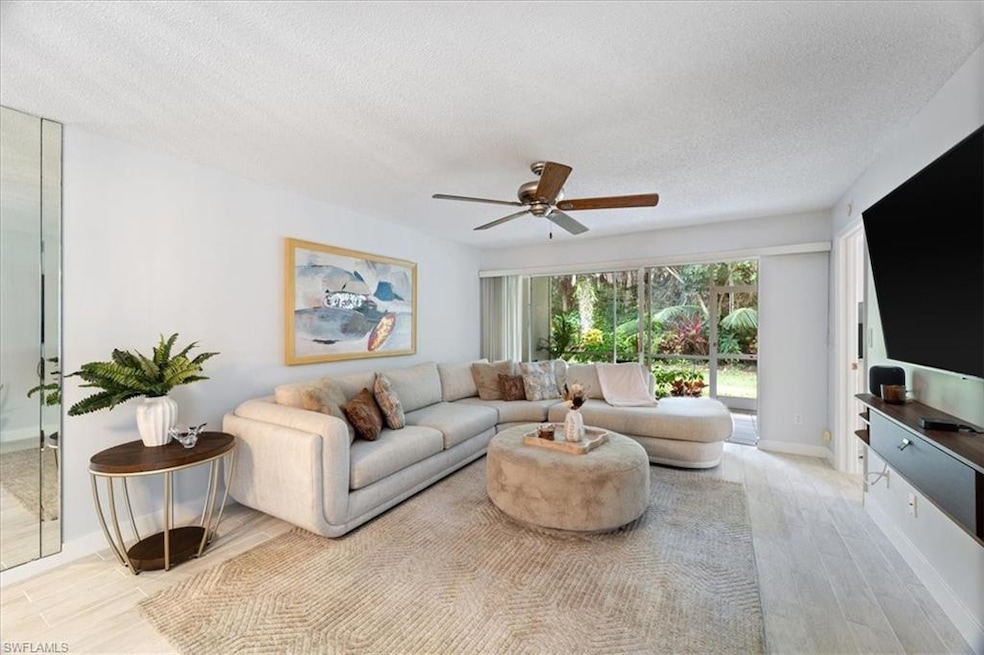 Living area with wood finished floors, ceiling fan, and a textured ceiling