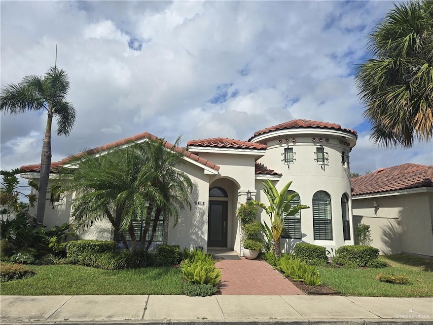 Mediterranean / spanish-style home with a tile roof, stucco siding, and a front lawn
