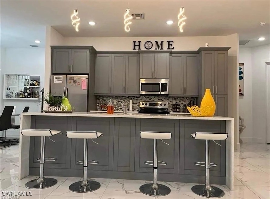 Kitchen with stainless steel appliances, light mar