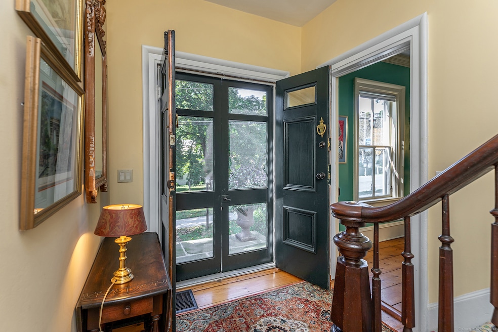 Stately French doors open to a cozy foyer with living room to the right in this photo.