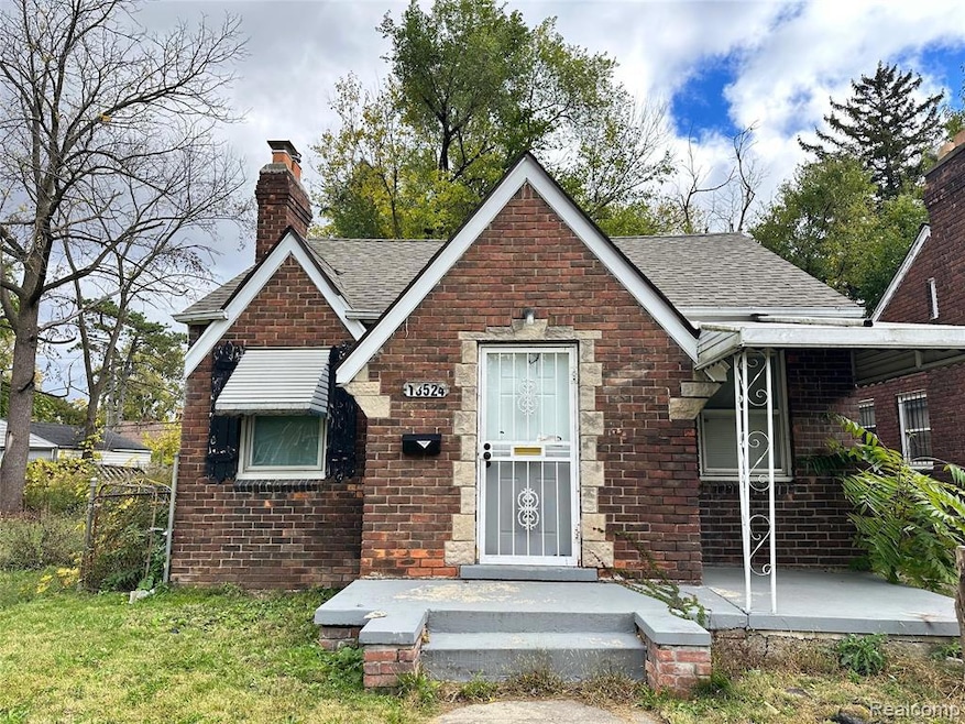 View of front facade with a chimney, a shingled roof, brick siding, a porch, and a front lawn