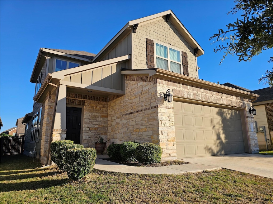 View of home's exterior featuring stone siding, concrete driveway, and board and batten siding