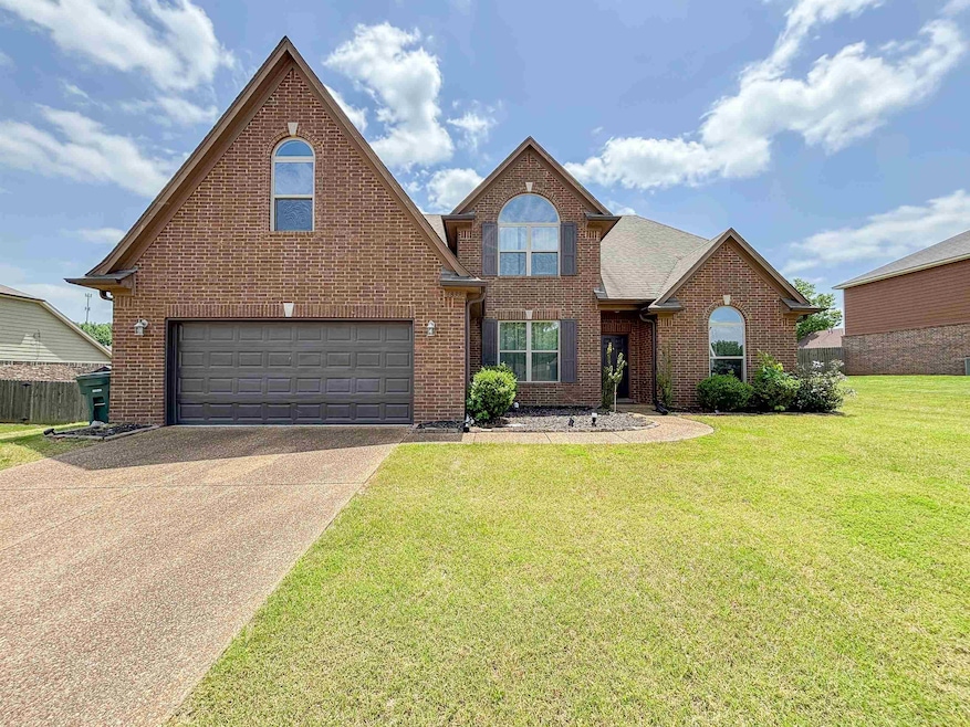 Traditional-style house with brick siding, a garage, and concrete driveway