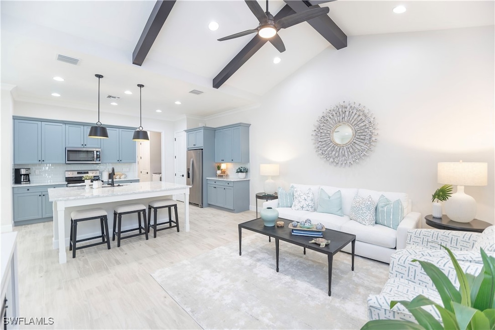 Living room with sink, ceiling fan, high vaulted c