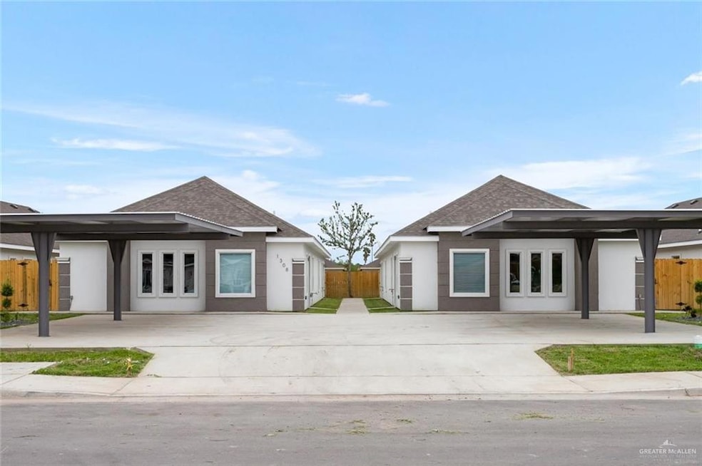 View of front facade with roof with shingles, fence, and stucco siding