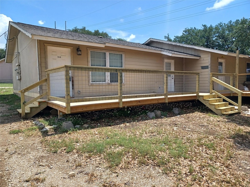 Back of property featuring a deck, a shingled roo