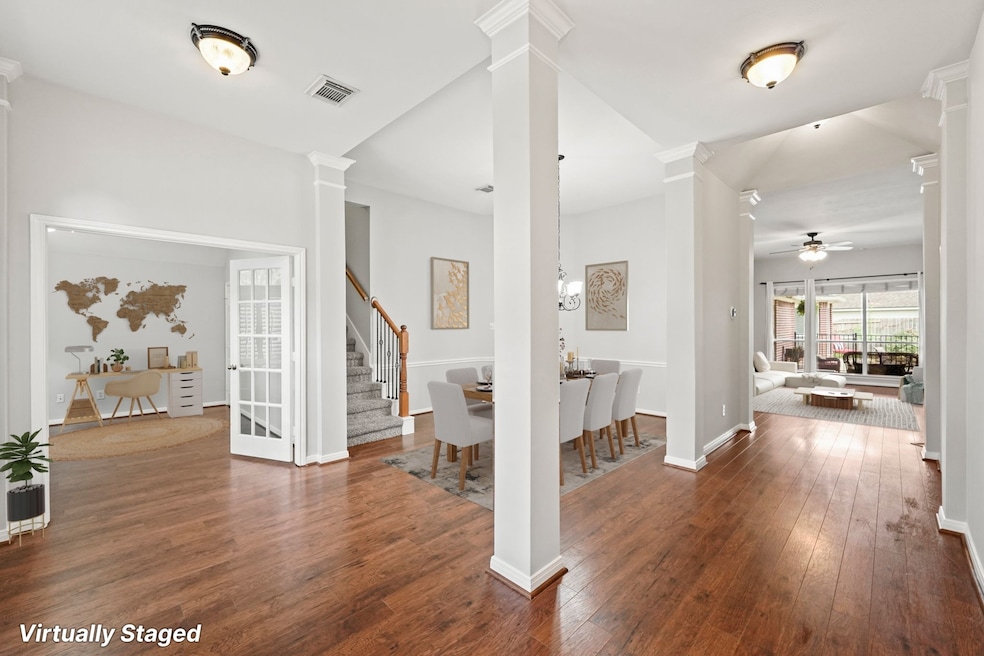 Stunning entry showcasing the formal dining suited for a 9 foot table, the study or possible exercise room and living room.  Virtually Staged Photo.