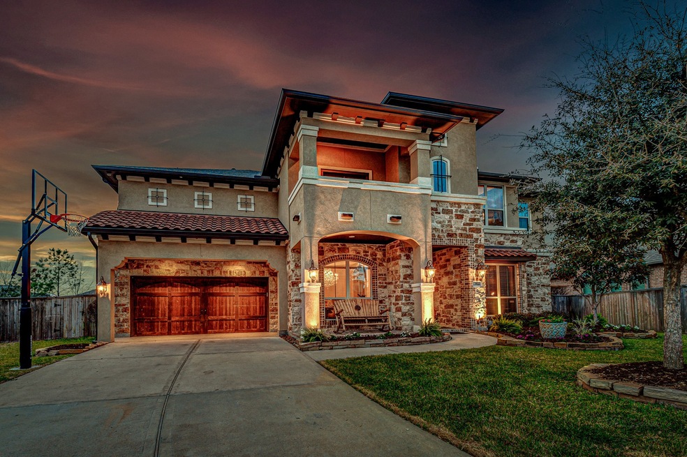 Gorgeous stone, wood, and stucco exterior with accent lighting