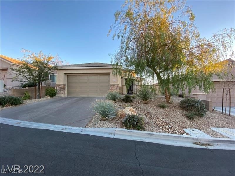 View of front of property with driveway, a garage,