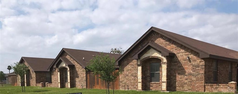 View of front facade featuring brick siding, stone siding, and a front lawn