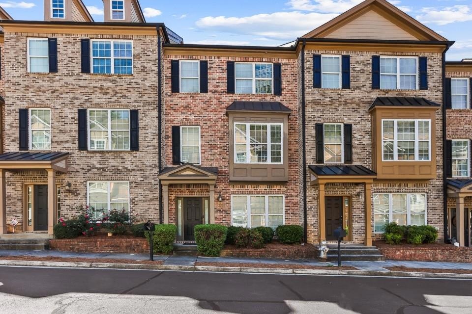 Colonial inspired home featuring brick siding