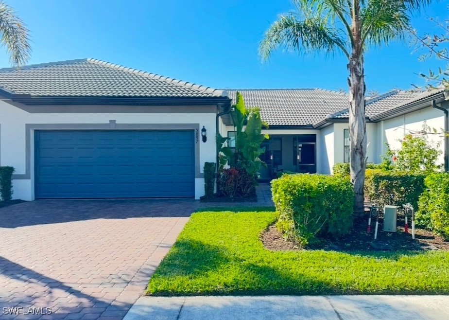 View of front of home with a garage and a front ya