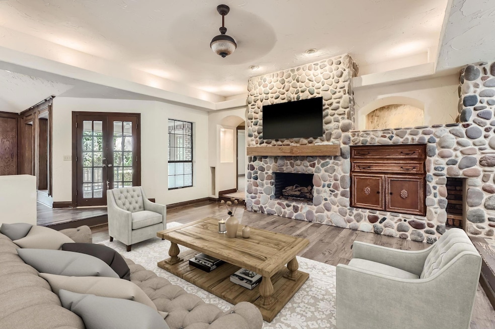 Living room with ceiling fan, a fireplace, and lig