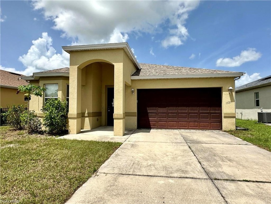 View of front facade with cooling unit, a garage, 
