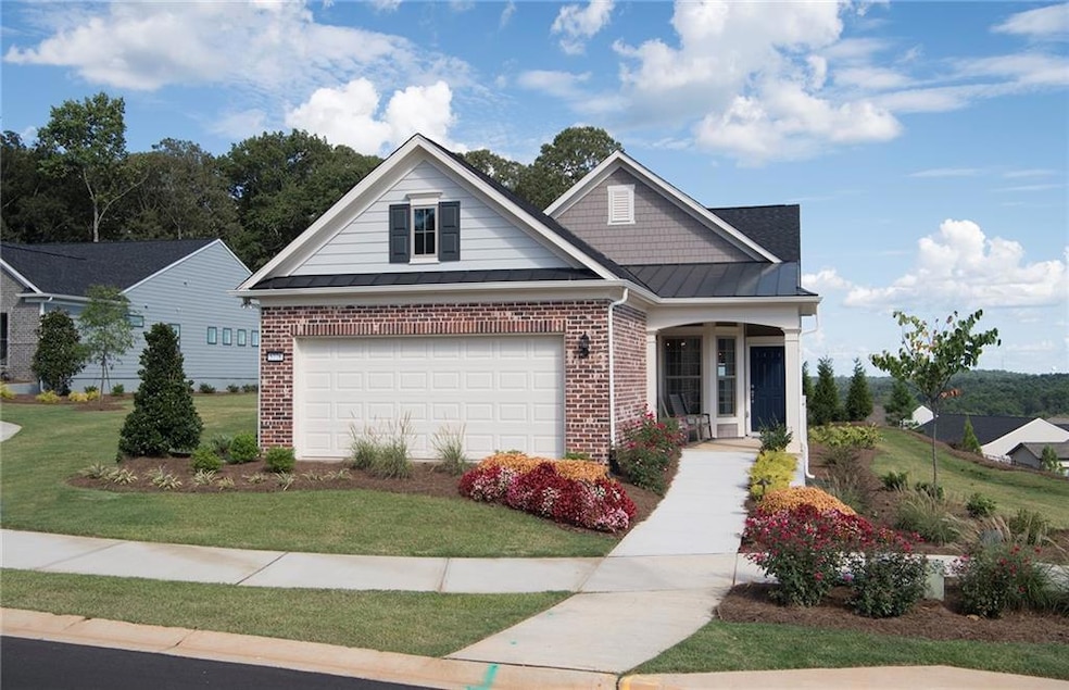 View of front of home featuring a standing seam roof, a metal roof, brick siding, and a front lawn