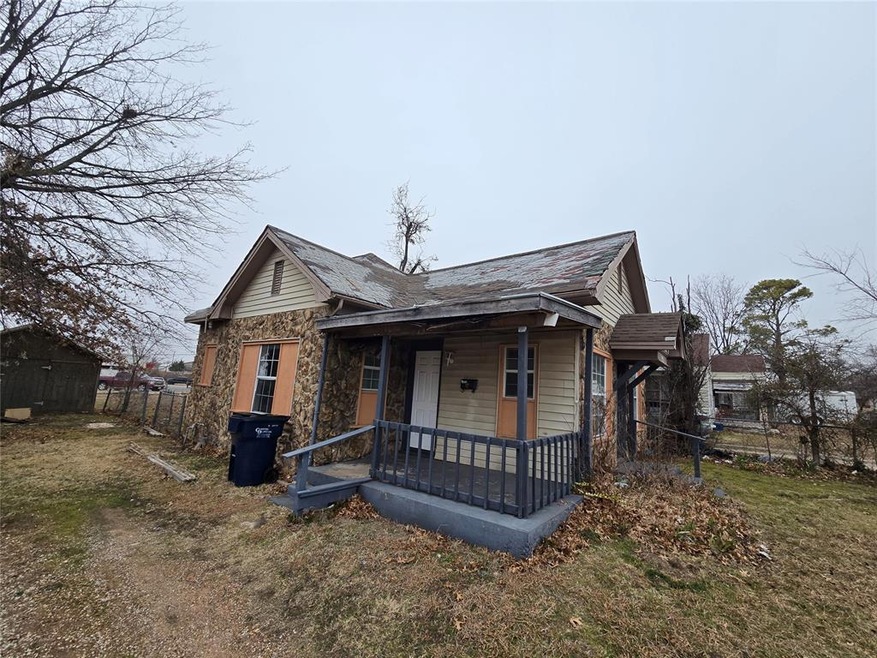 View of front of home with a front yard and covere