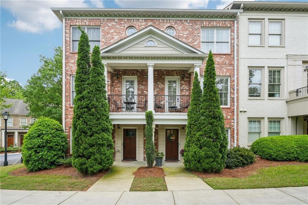 View of front of property featuring a balcony, brick siding, and a porch