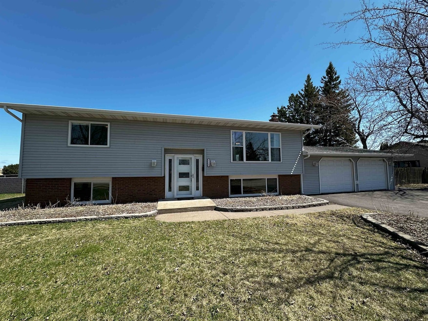 Bi-level home with an attached drive through garage, and asphalt driveway