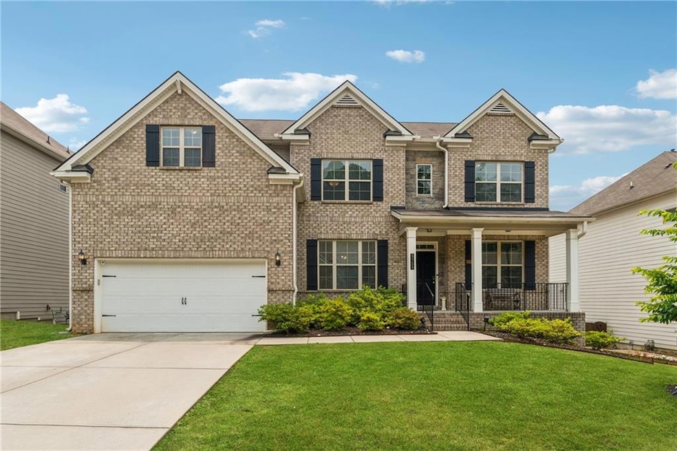 Craftsman inspired home with covered porch, brick siding, and a front lawn