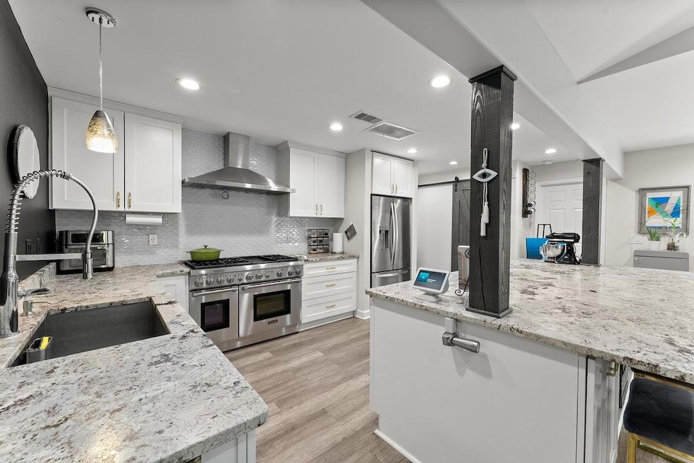 Kitchen with wall chimney range hood, stainless st