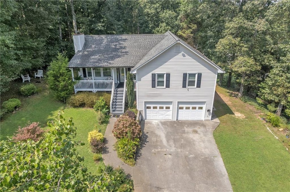 View of front facade with stairs, a front yard, driveway, a shingled roof, and covered porch