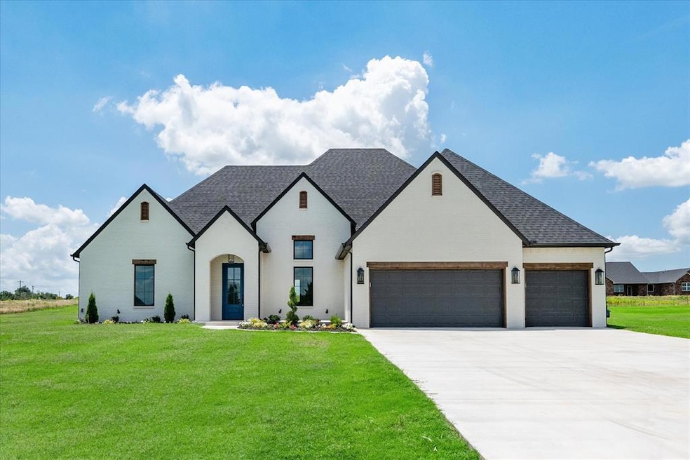 French country style house with a garage, roof with shingles, concrete driveway, a front lawn, and brick siding
