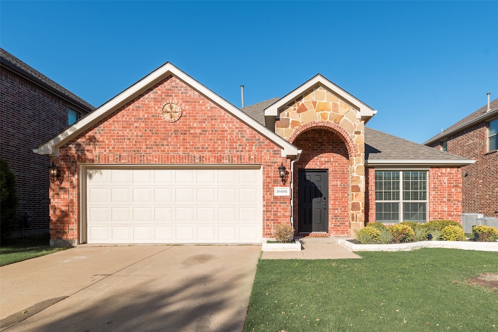 Traditional home with brick siding, concrete driveway, stone siding, an attached garage, and a front lawn