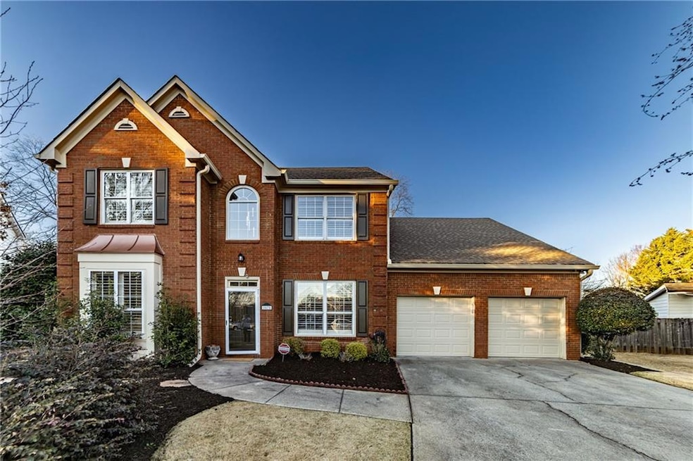 View of front of home featuring a garage, brick si