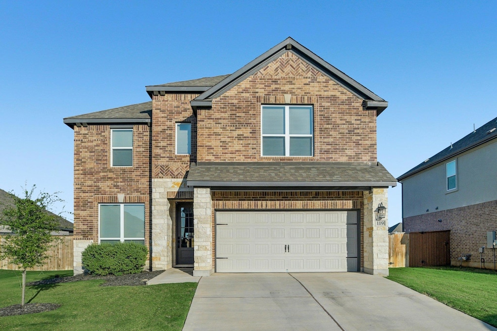 Traditional-style home with brick siding, roof with shingles, a garage, and concrete driveway