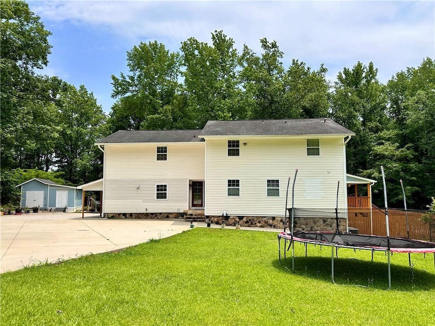 Front of property with  concrete driveway, entry steps, and an outdoor structure