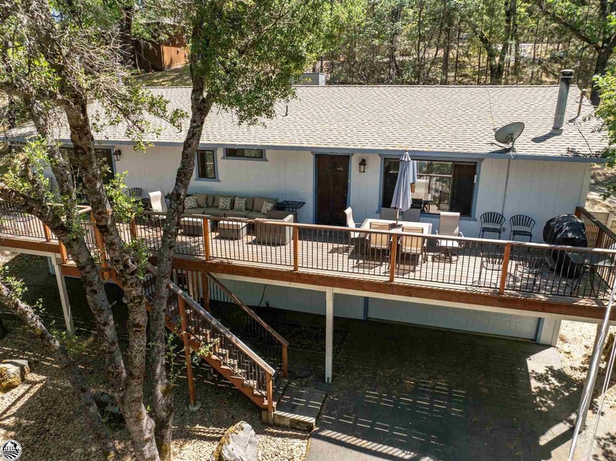Rear view of house featuring an outdoor living space, a patio, and a wooden deck