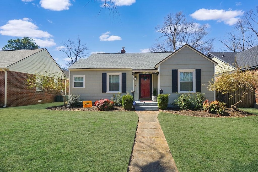 View of front of property featuring a shingled roof, a chimney, fence, and a front yard