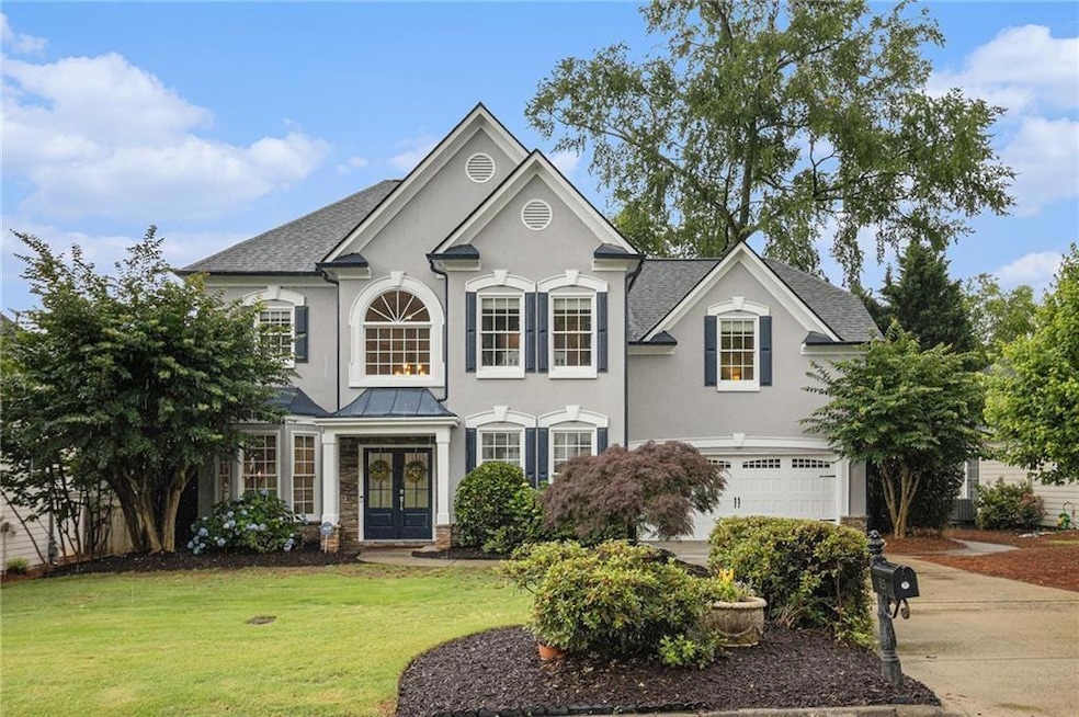View of front of home featuring french doors, an attached garage, a front yard, concrete driveway, and stucco siding