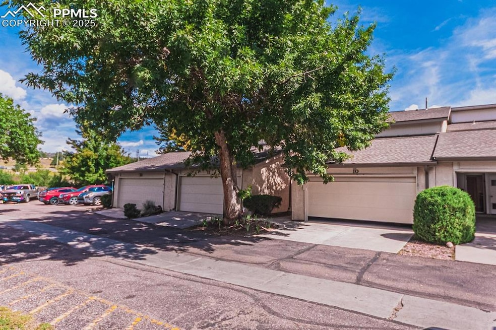 View of front of home with a shingled roof, stucco siding, driveway, and a garage
