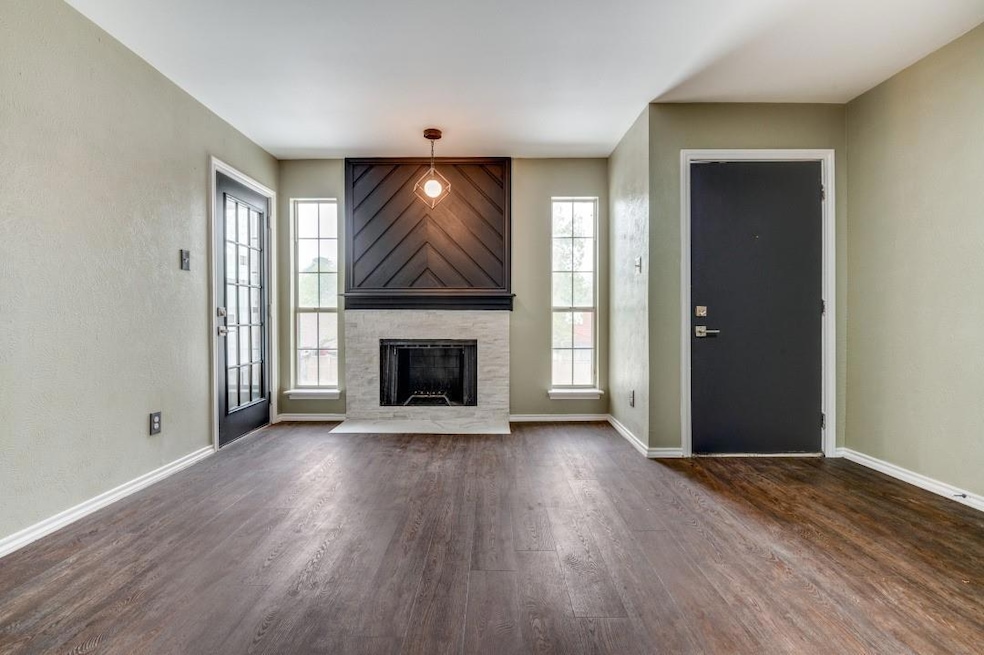 Living room with baseboards, a fireplace, and dark