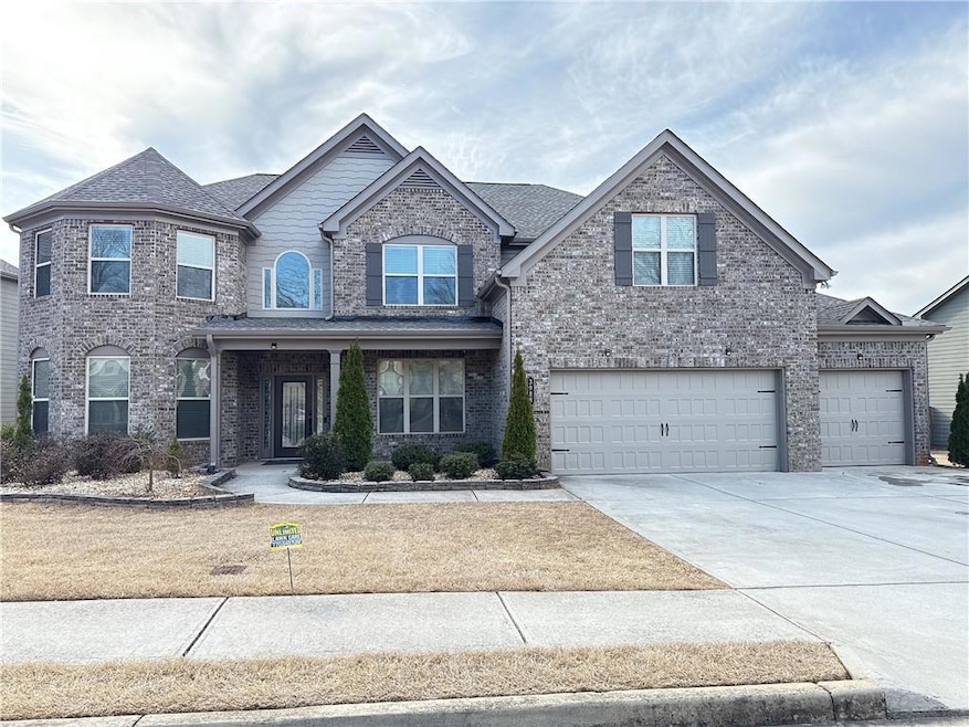 View of front of home featuring a garage, brick siding, driveway, and roof with shingles