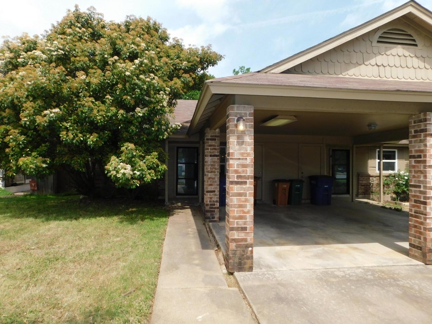 View of side of home with a shingled roof, concre