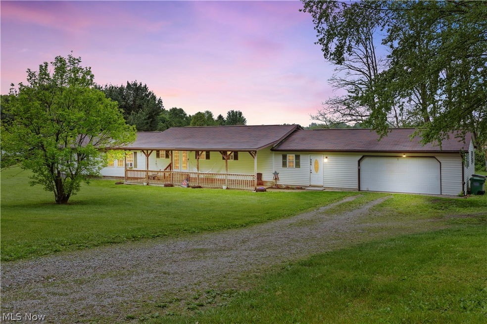 Ranch-style home with a porch, a lawn, and a garage