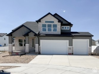 Craftsman house with concrete driveway, a garage, and stone siding